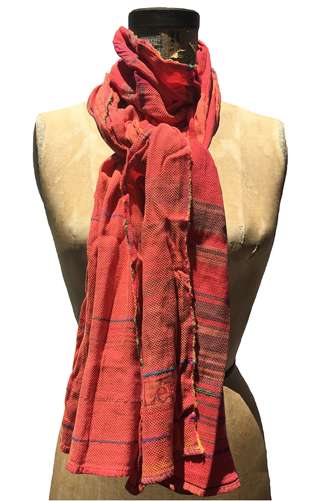 The Letol Desiree scarf has an intricate weave in warm oranges and reds with hints of blue and green.